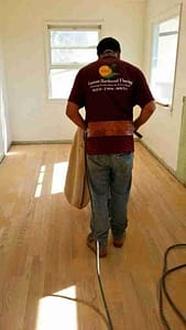 Professional contractor sanding a hardwood floor